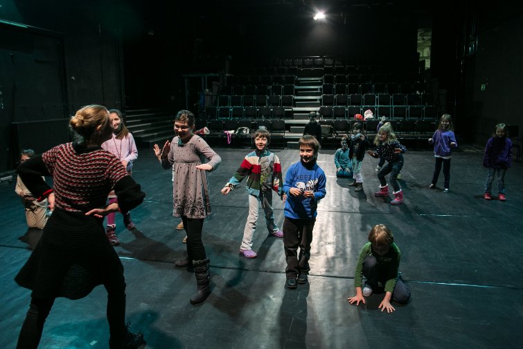 scena teatralna, grupa dzieci tańcząca z prowadząca warsztaty