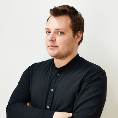 portret młodego mężczyzny w brązowych włosach, ubrany jest w czarną bluzkę z długim rękawem