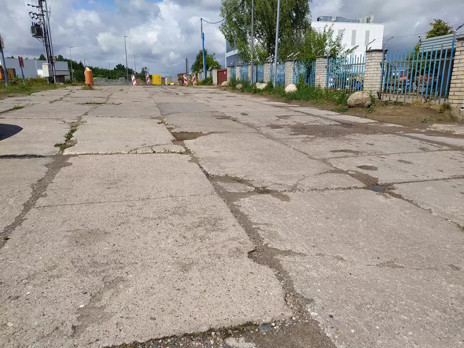 Zdjęcie przedstawia zniszczone płyty na ulicy Orzechowej przed naprawą.