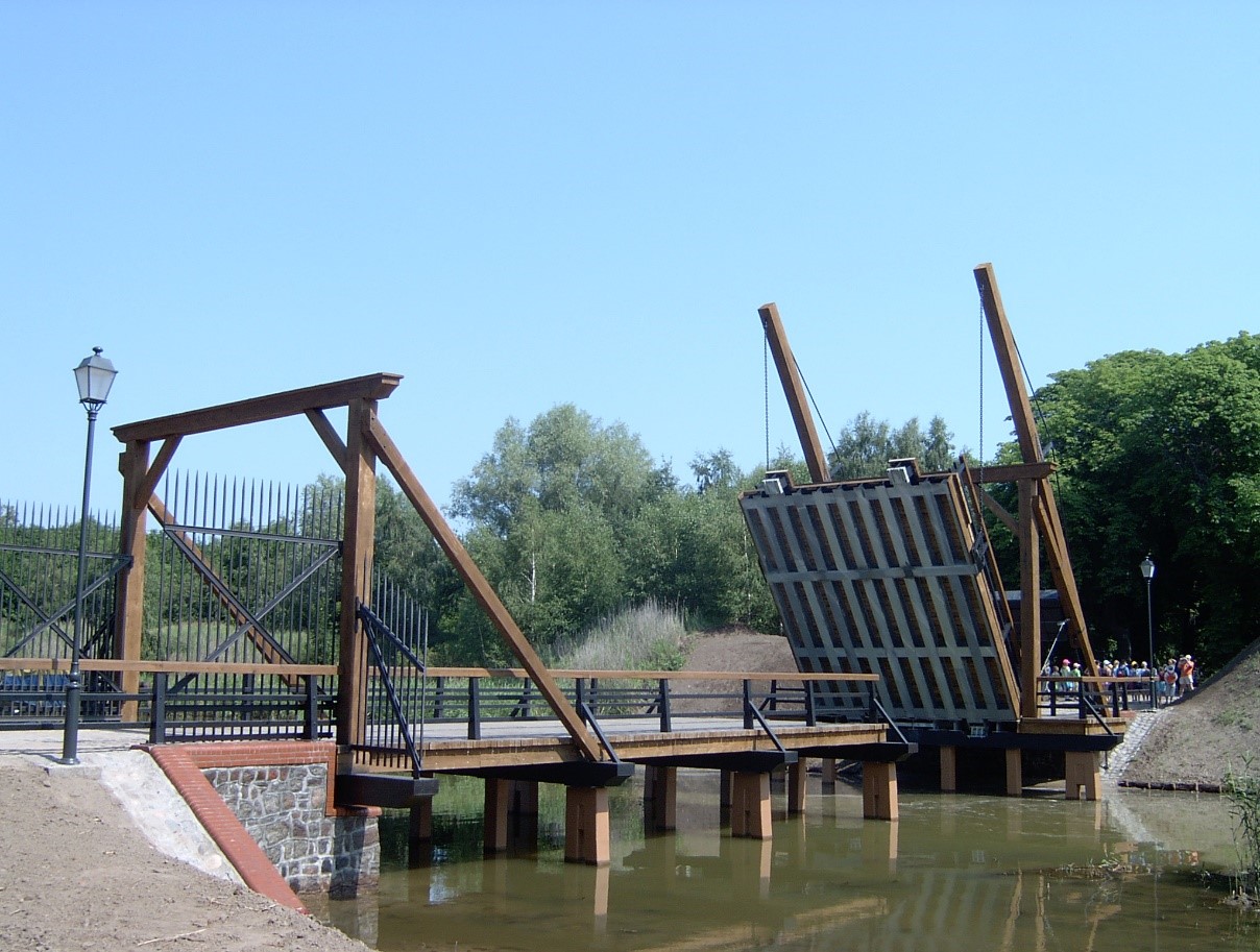 Zdjęcie przedstawia most zwodzony przez zewnętrzną fosę Twierdzy Wisłoujście.