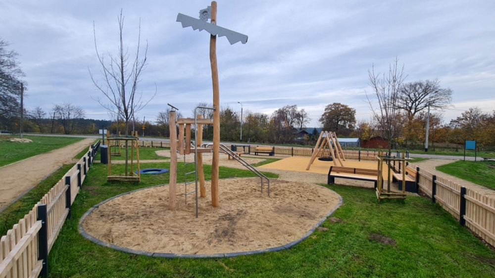 widok na nowy plac zabaw, otoczony drewnianym płotem