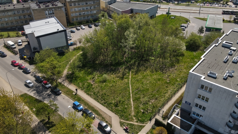 widok z lotu ptyaka na park Uphagenów, wiodoczna ziieleń na której zostanie zrealkizowany projekt, w koło budynek przychodni, budynek mieszkalny i fragment stacji benzynowej