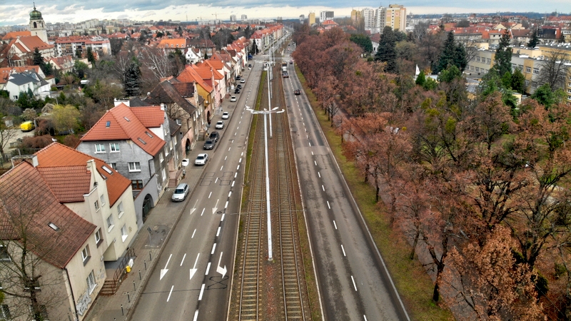 zdjęcie przedstawia widok na jezdnie z góry w mieście pomiędzy budynkami