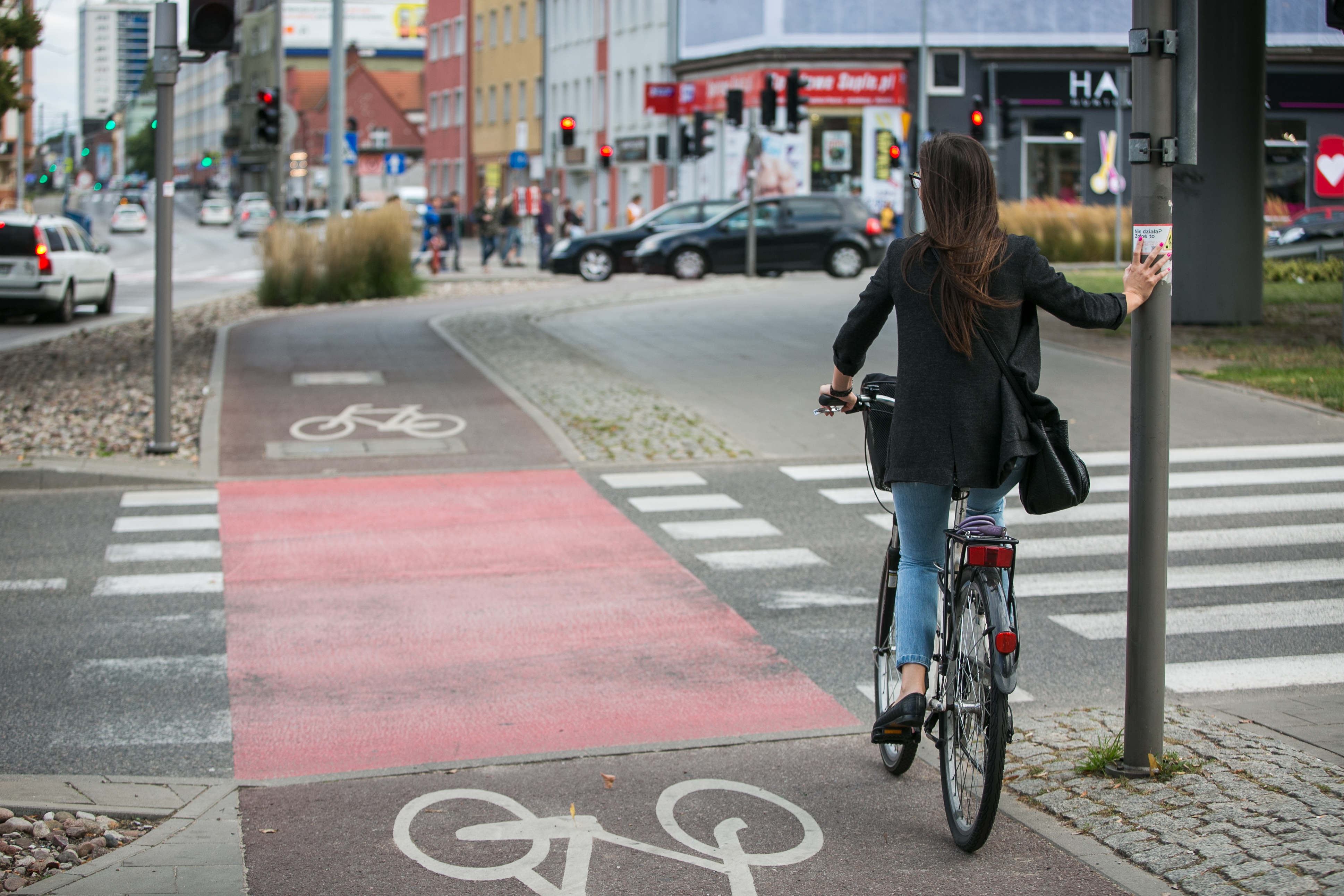 widok na skrzyżowanie, kobieta na rowerze czeka na zmianę świateł