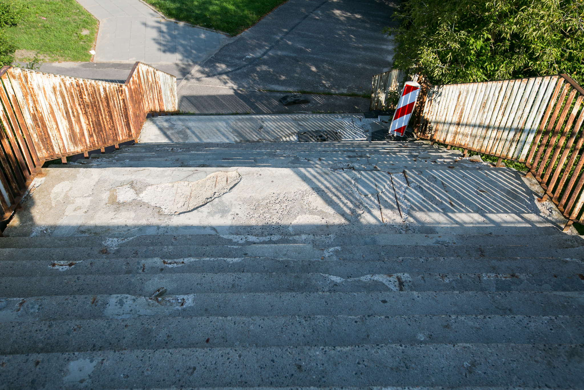 Na zdjęciu widoczne są schody kładki nad al. Rzeczypospolitej i al. Jana Pawła II przed remontem