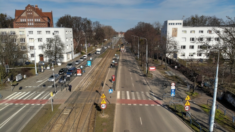 zdjęcie przedstawia widok na jezdnie z góry w mieście pomiędzy budynkami