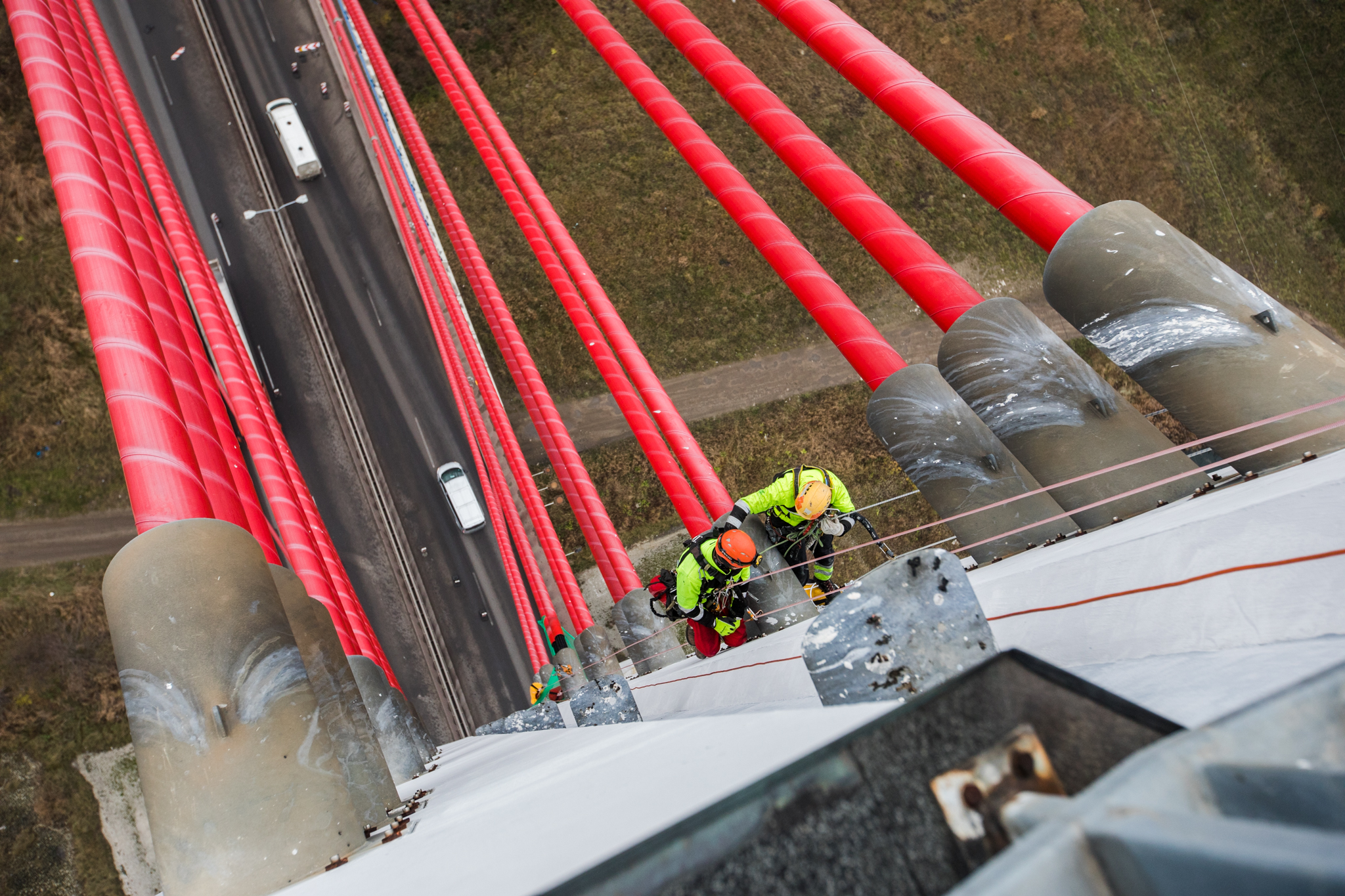 Na zdjęciu widoczni są alpiniści w trakcie naprawy cięgien mostu wantowego
