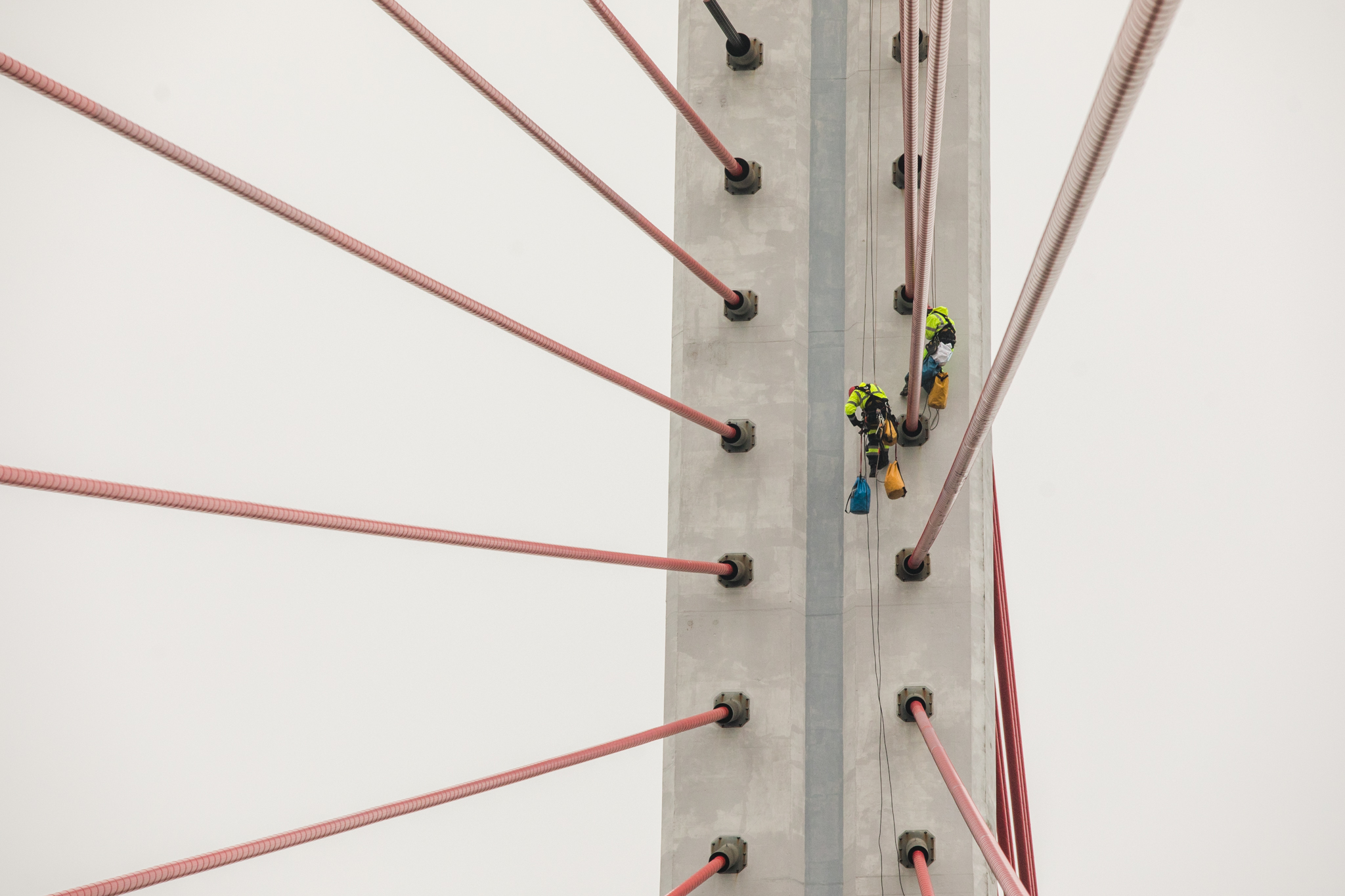Na zdjęciu widoczni są alpiniści w trakcie naprawy cięgien mostu wantowego