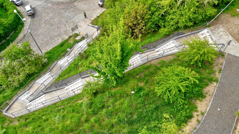 widok na nowe schody z lotu ptaka, widoczna zieleń, fragment ulicy z zaparkowanymi autami