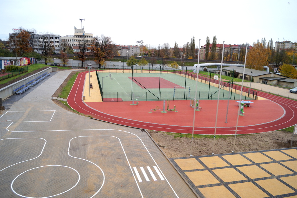 widok na miasteczko rowerowe, siłownię zewnętrzną i ogrodzone boisko o syntetycznej nawierzchni 